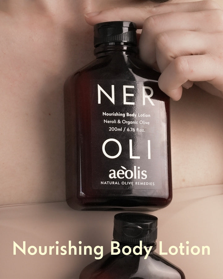 Nourishing body lotion bottle labeled NEROLI by Aeolis held by a hand.