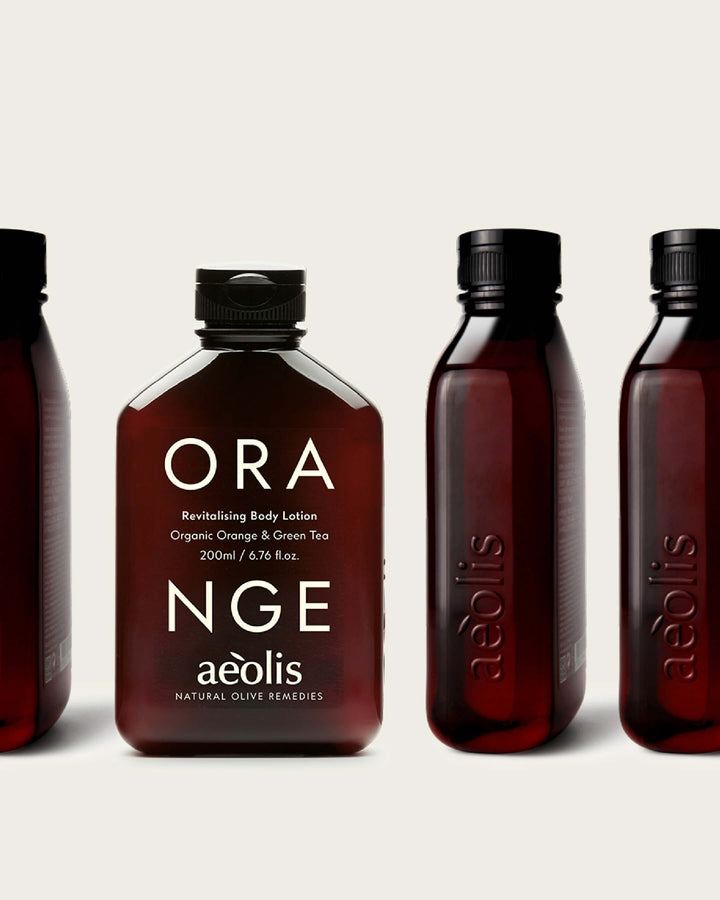 Orange Aeolis body lotion bottles on a light background