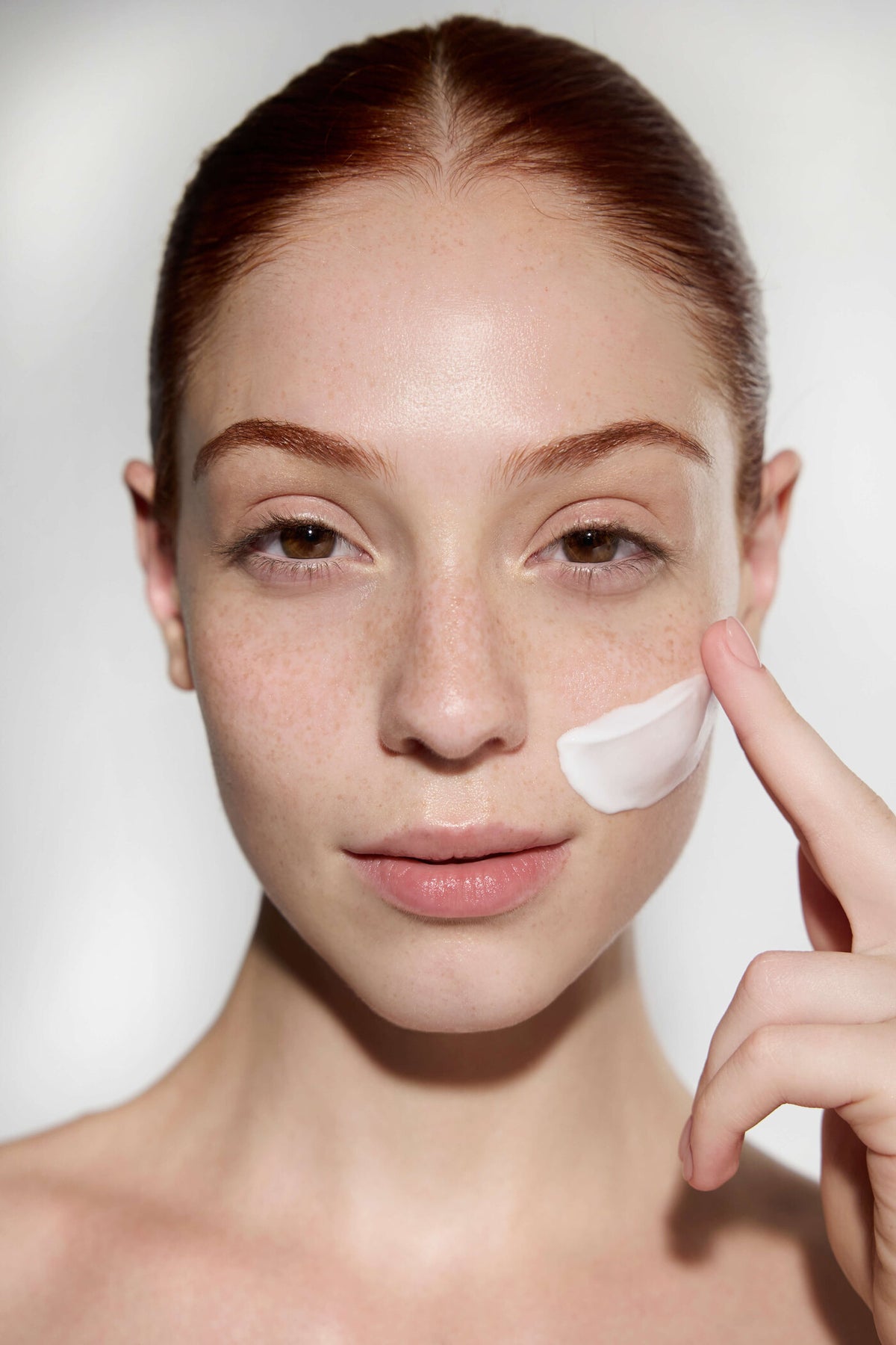 Model applying Garden face cream to her cheek