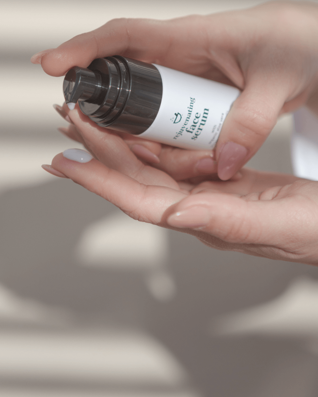 Hand holding a skincare bottle labeled &